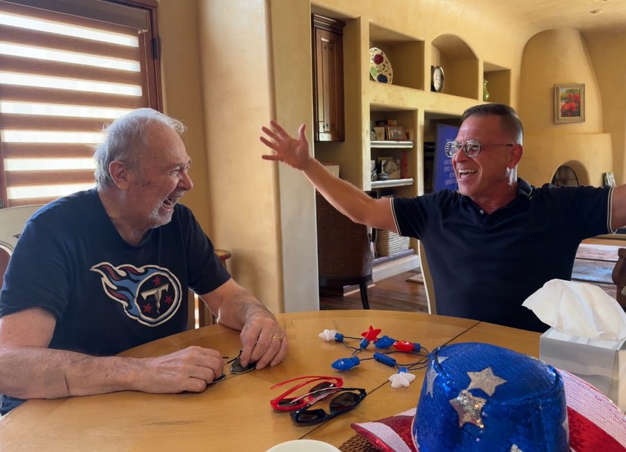A Caregiver and his client laughing together at the kitchen table